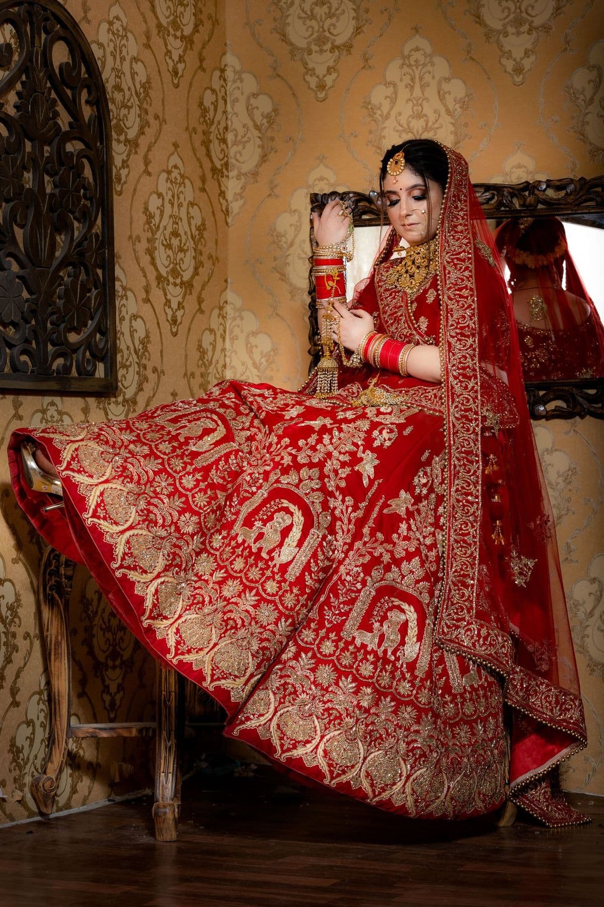 Woman twirling a red and gold bridal lehenga