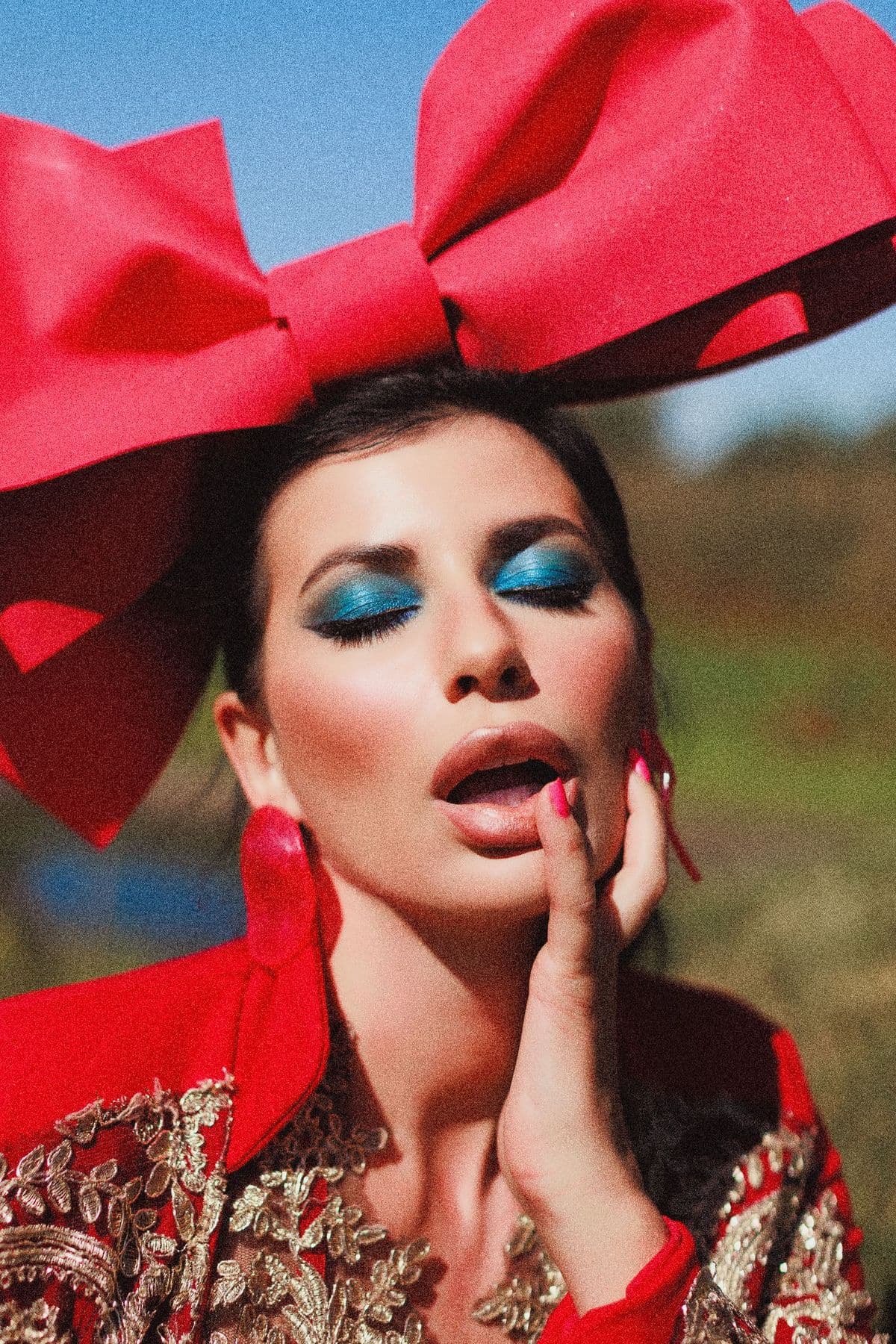 Model with a giant red bow and blue eyeshadow